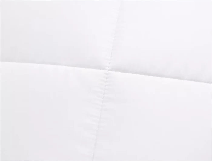 White quilted mattress protector with stitched detailing for cozy bedding comfort