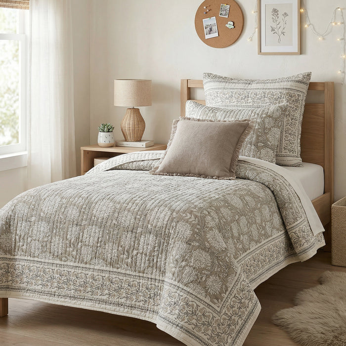Neatly made bed with patterned bedding in a well-lit bedroom.