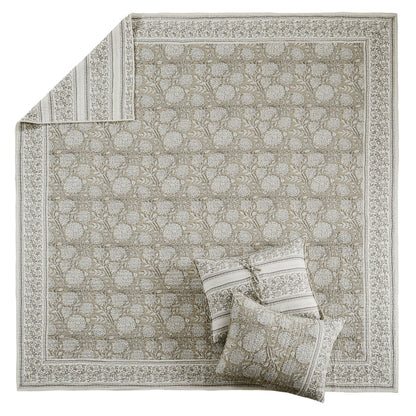 Decorative rug with intricate patterns and matching pillows on a white background