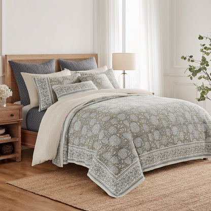 Bedroom with floral-patterned comforter and pillows on a bed.
