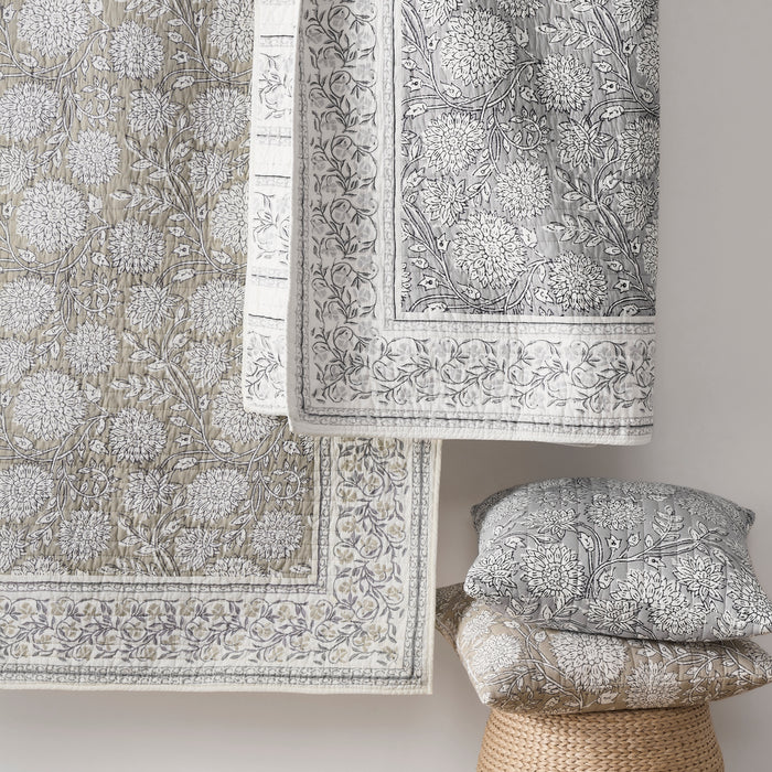 Floral patterned fabric with a pillow and rug on a neutral background
