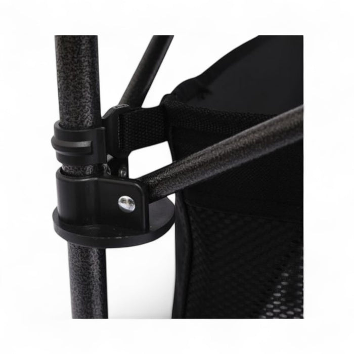 Close-up of a black mesh chair with a strap and metal clip on a white background