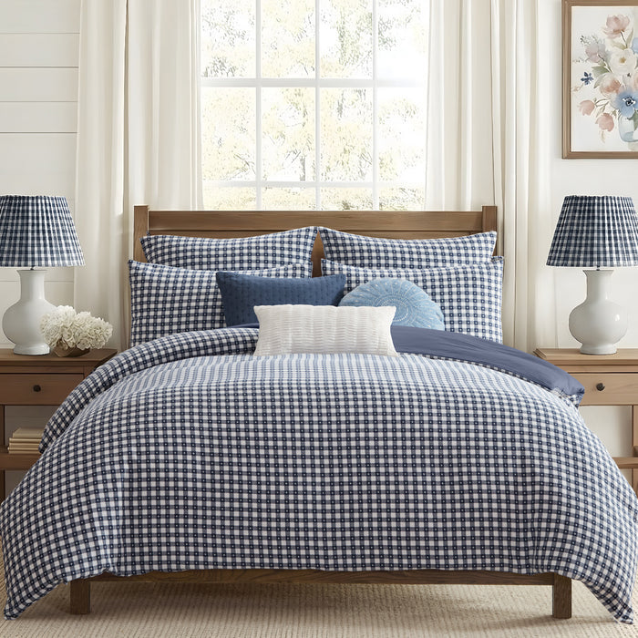 Bedroom with blue and white checkered bedding and matching lamps.