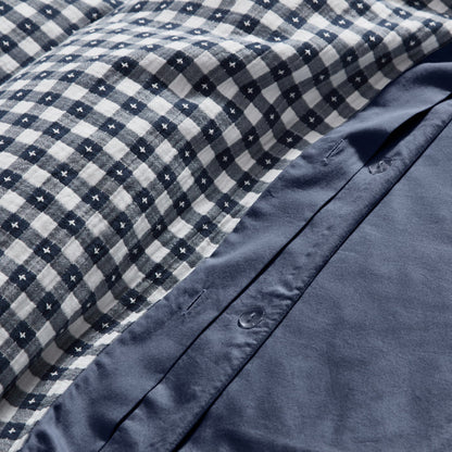 Close-up of blue checkered fabric with a buttoned blue garment underneath