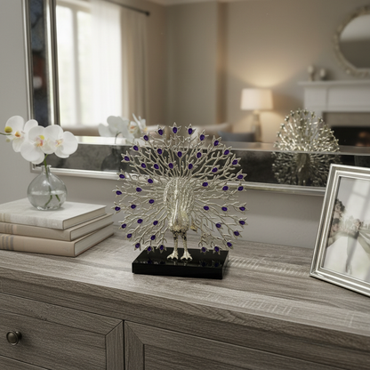 Silver peacock figurine with purple gemstones on wooden dresser, home decor accent piece