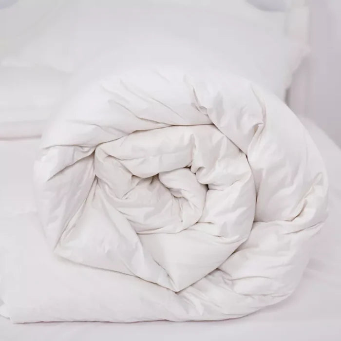 White plush comforter on a bed, ideal for cozy sleep and bedroom decor