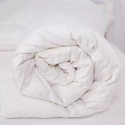 White plush comforter on a bed, ideal for cozy sleep and bedroom decor