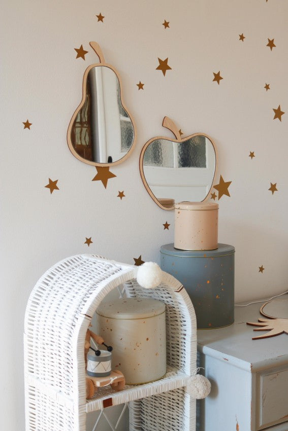 Apple and pear wooden mirrors displayed on shelf with brown stars and wicker storage basket