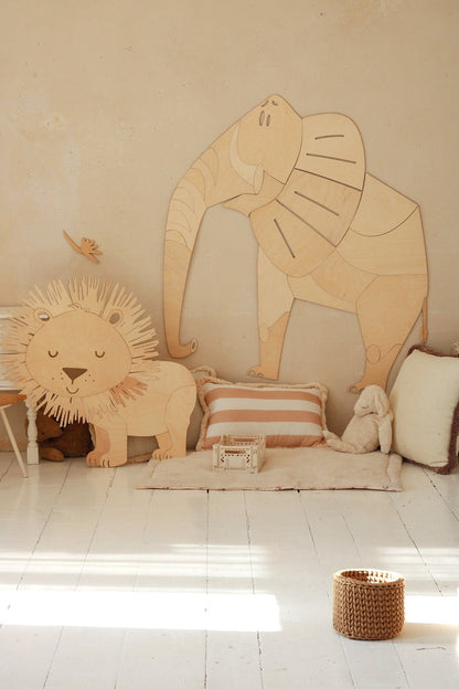 Wooden elephant and lion wall decorations styled with cushions and storage in bedroom