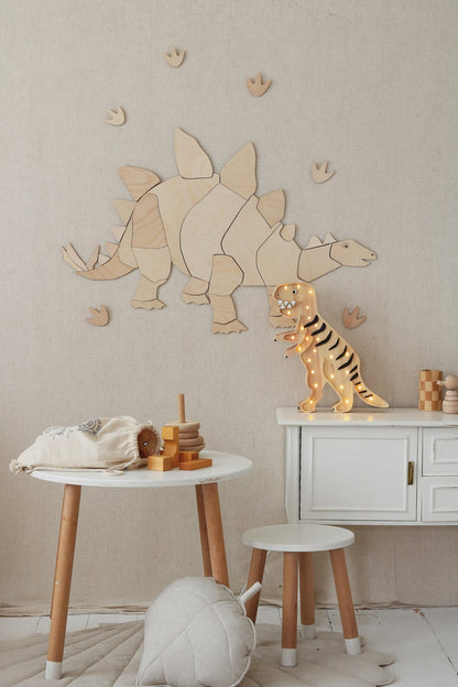 Close-up of natural wood stegosaurus wall puzzle with tan and brown dinosaur figurines