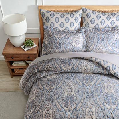 Bedroom with paisley-patterned bedding and a wooden nightstand.