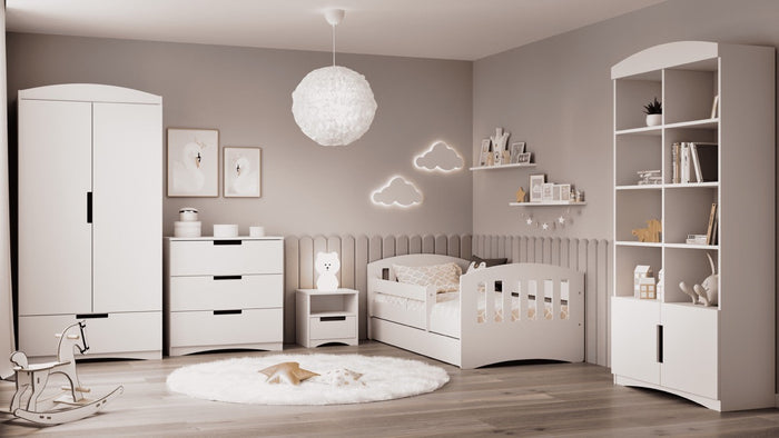 Classic white bedside table styled in modern nursery room with coordinating furniture