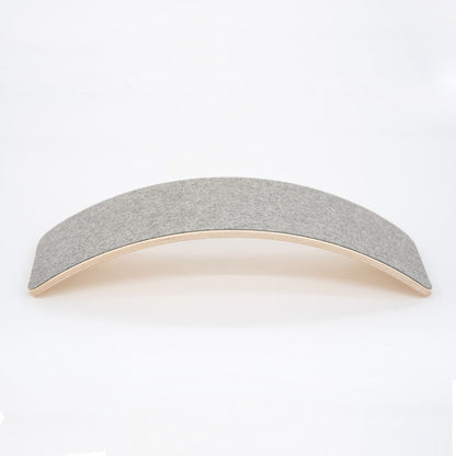 Wooden balance board with grey felt top surface, curved design side view