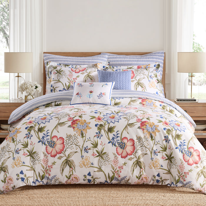 Floral bedding set on a bed with matching pillows in a bedroom setting.